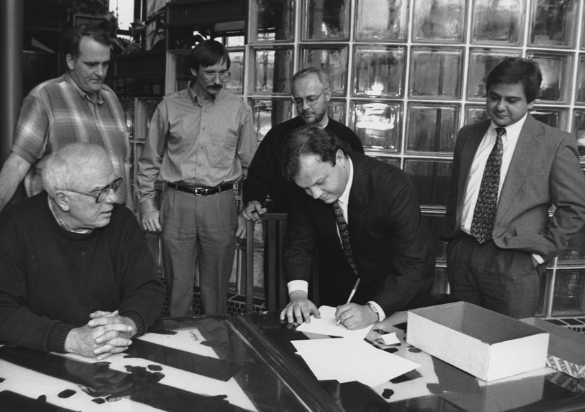 During a January 5, 1996, meeting in Nashville, Tennessee, Perry Stambaugh, editor of Penn Lines magazine, signs papers formally incorporating National Country Market Sales Cooperative (NCM). Looking on, from left, are fellow NCM incorporators Bill Roberts, editor of Oklahoma Living; John Bruce, associate editor with Cooperative (then Rural) Living (VA); Jim McCarty, editor, Rural Missouri; Rod Guge, editor, The Tennessee Magazine; and George Macias, editor, Texas Co-op Power and NCM’s first executive director. 