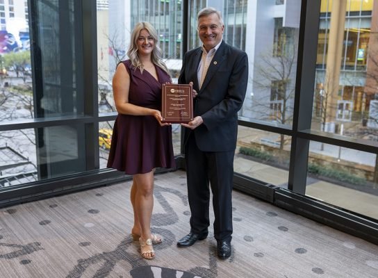 North Dakota Living Editor Cally Peterson accepts the 2025 Haggard Award from NRECA CEO Jim Matheson